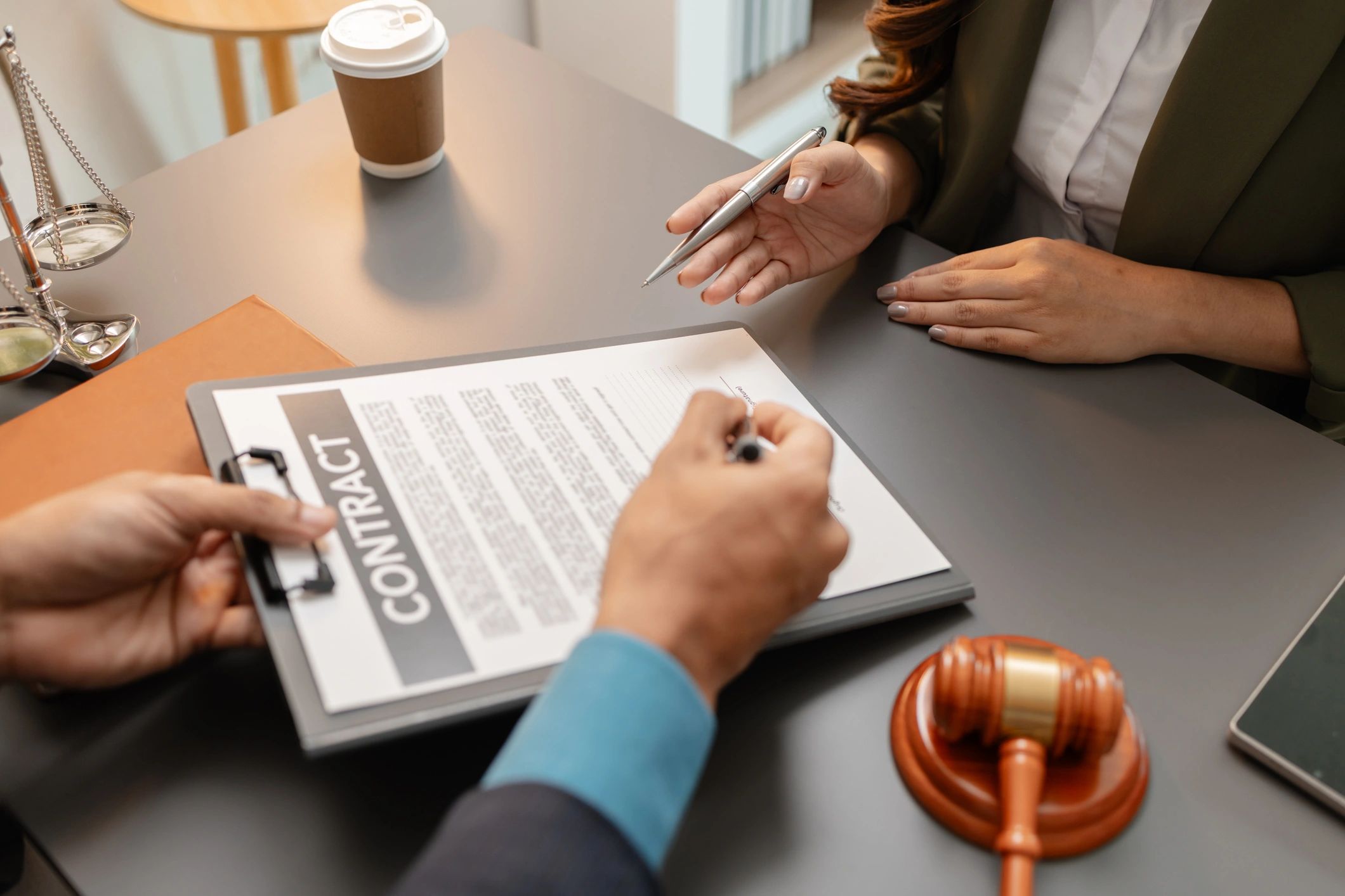 Professional consultation reviewing and signing documents at a desk.